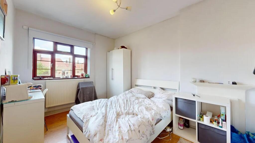 A bright double bedroom featuring a comfortable...
