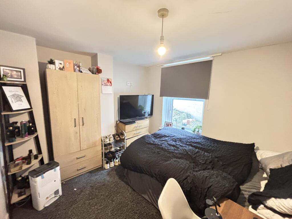 A cozy bedroom featuring a large bed positioned...