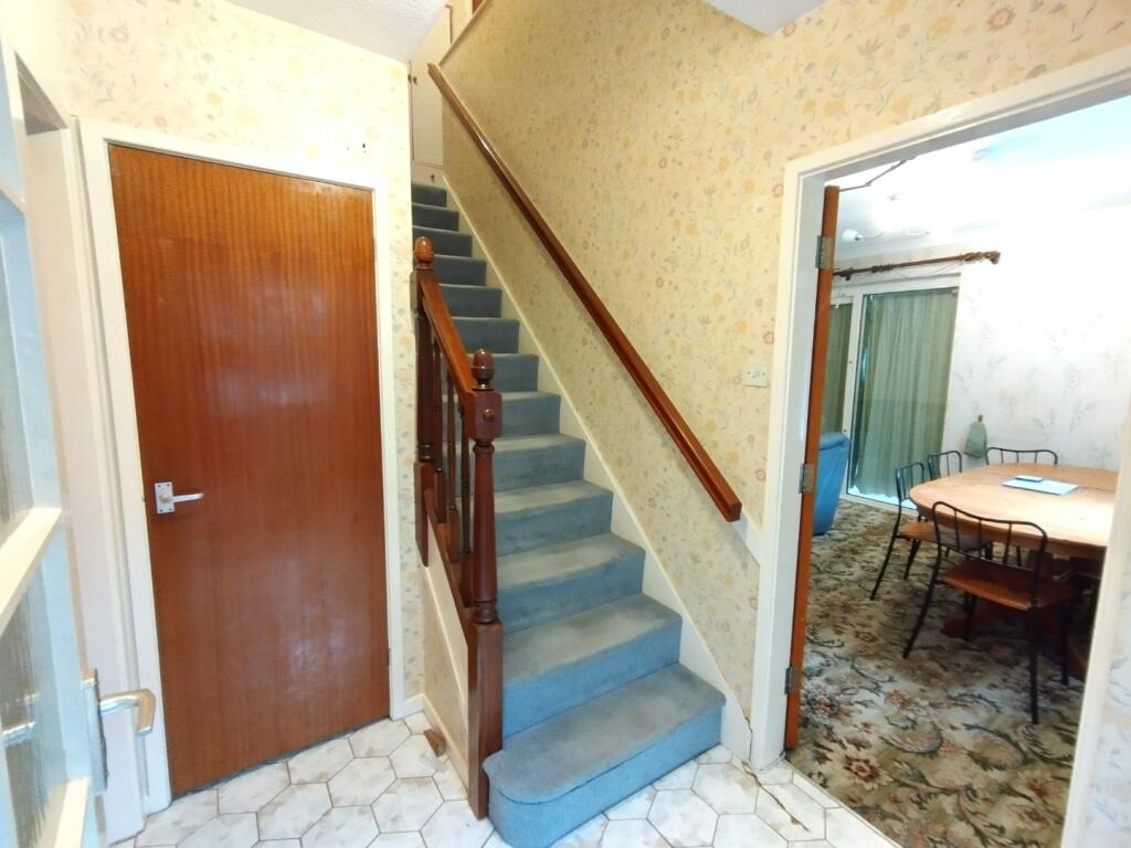 Welcoming entrance hallway with carpeted stairc...