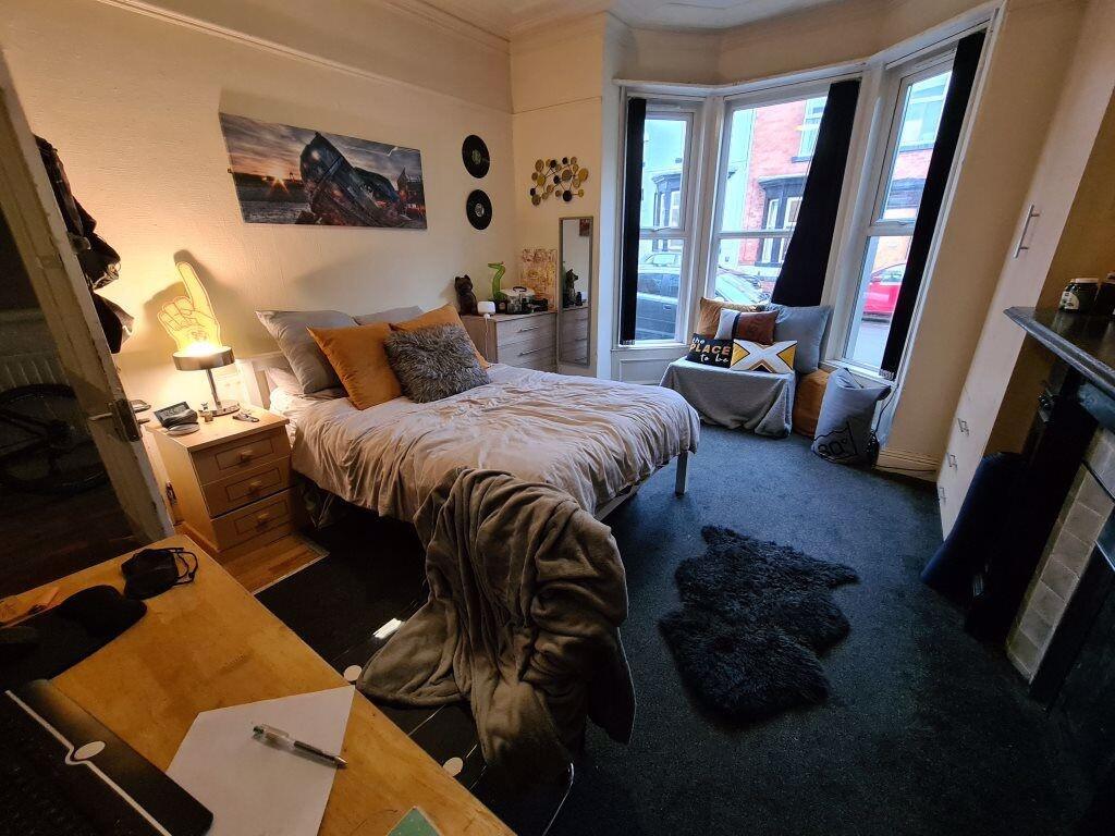 A cozy and well-decorated master bedroom featur...