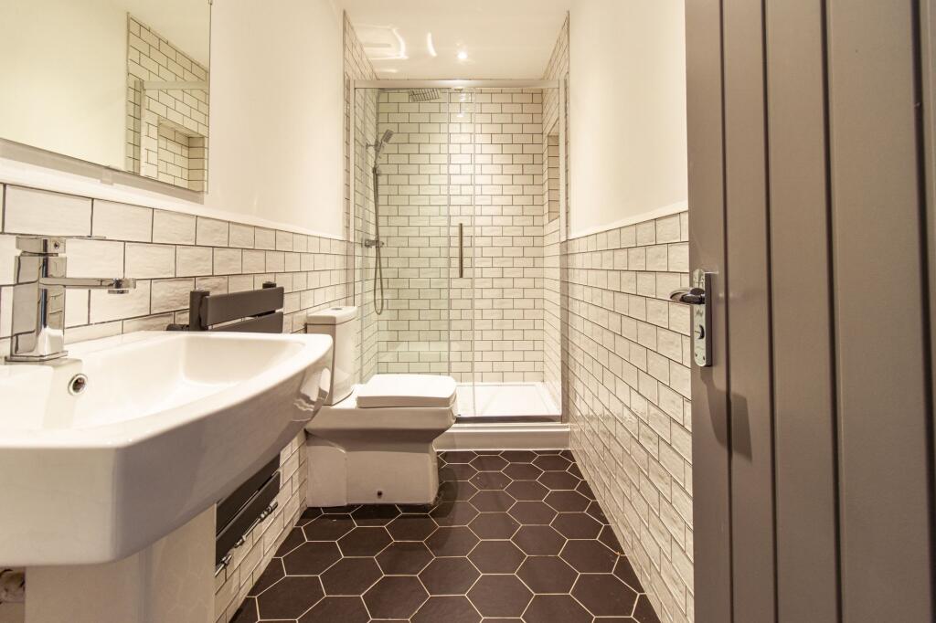 Modern tiled bathroom with a walk-in glass show...