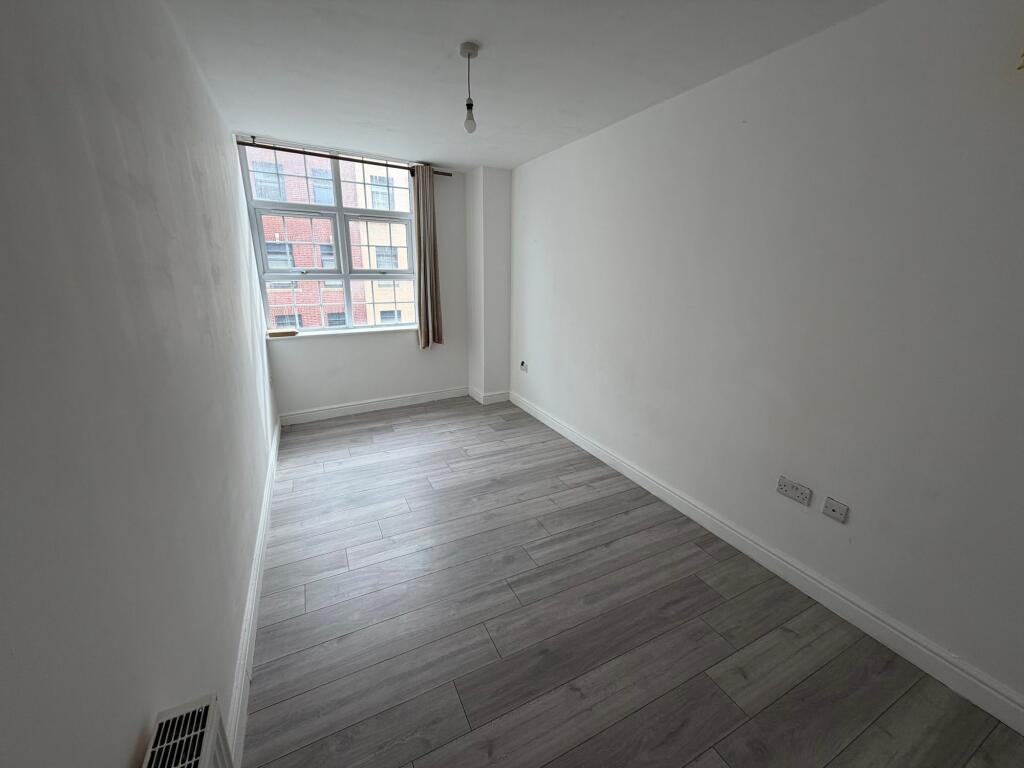 Bright and airy bedroom featuring a large windo...