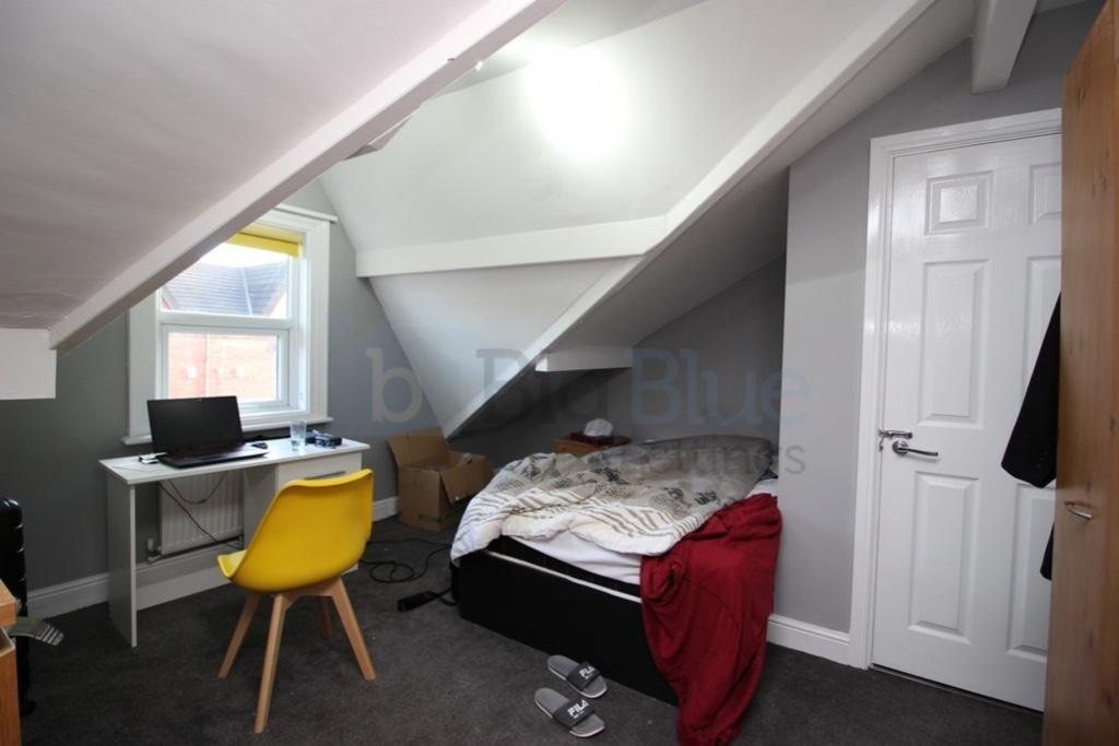 Cozy single bedroom featuring a comfortable bed...