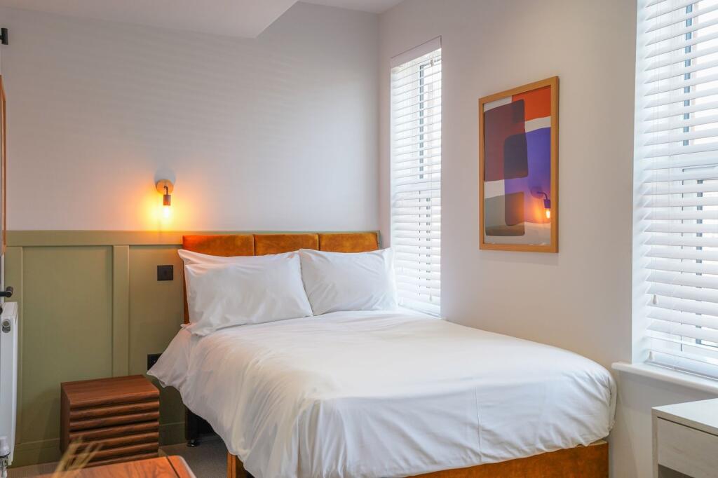 A bright and inviting double bedroom featuring ...