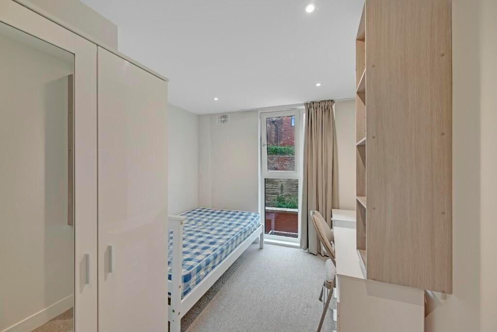 A bright and tidy single bedroom featuring a co...