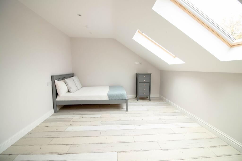 Bright and airy master bedroom featuring a comf...
