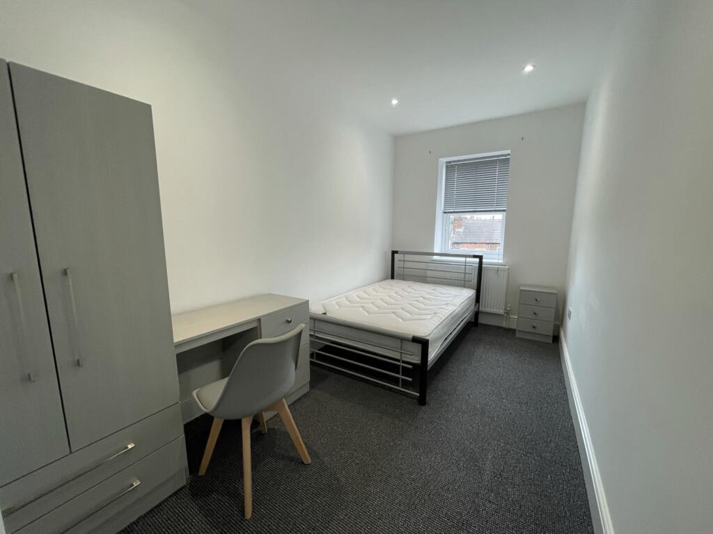 A spacious and tidy double bedroom with modern ...