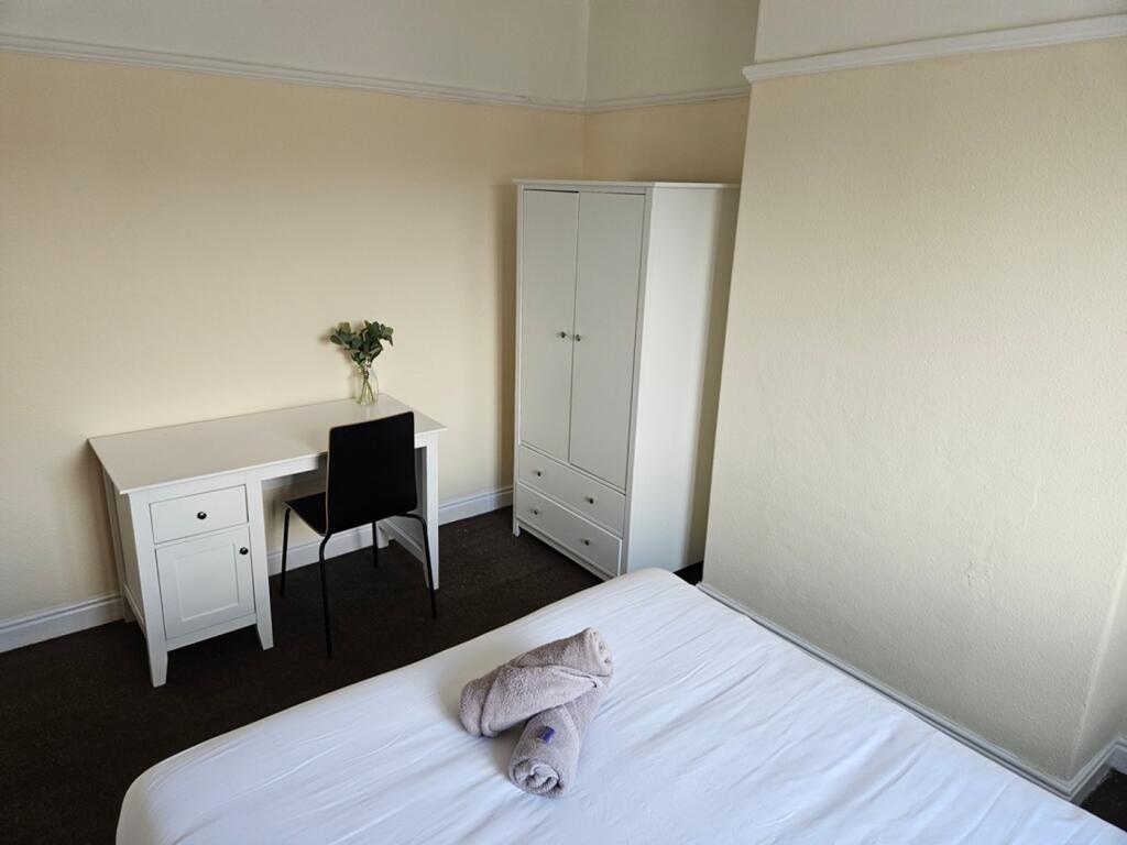 A bright and tidy double bedroom featuring a de...