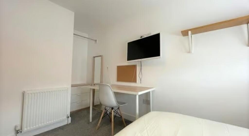 A neat and functional single bedroom featuring ...