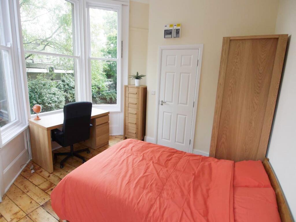 A bright and cozy bedroom featuring a comfortab...