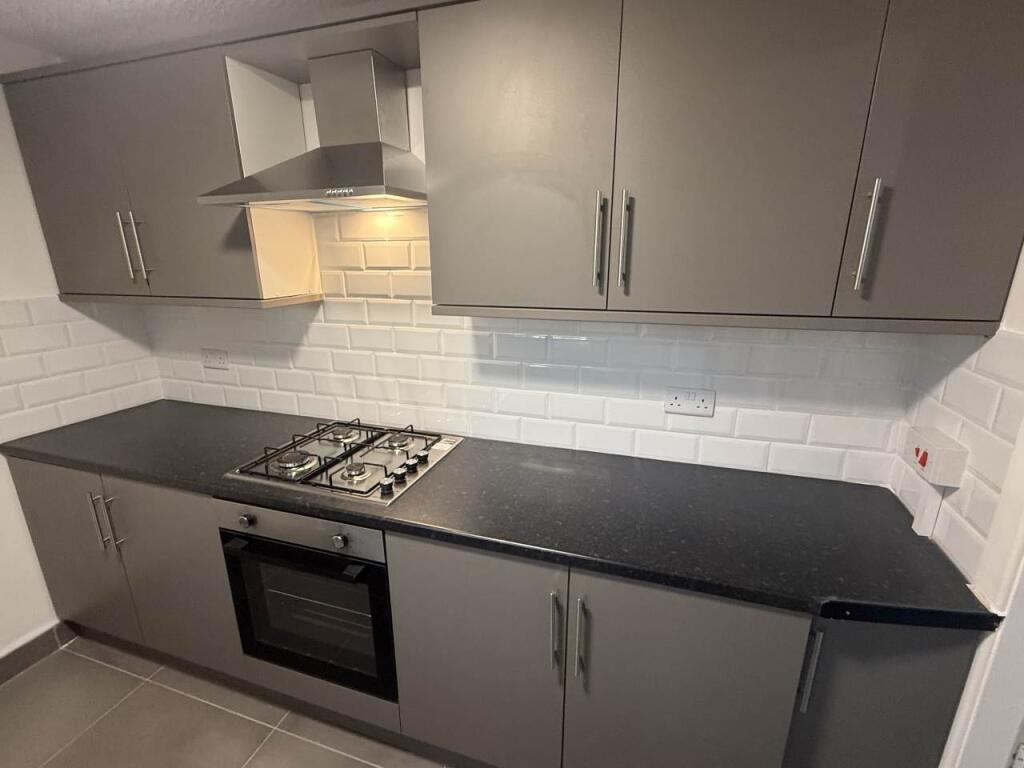 A modern kitchen featuring sleek gray cabinets,...