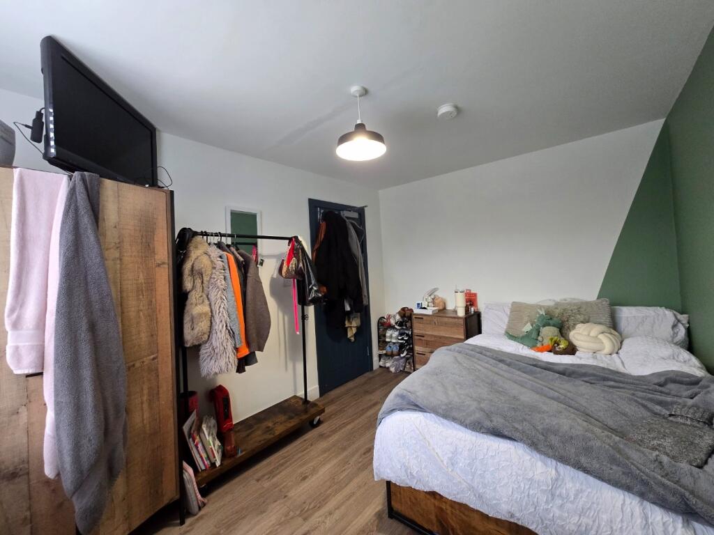 A spacious master bedroom featuring a comfortab...