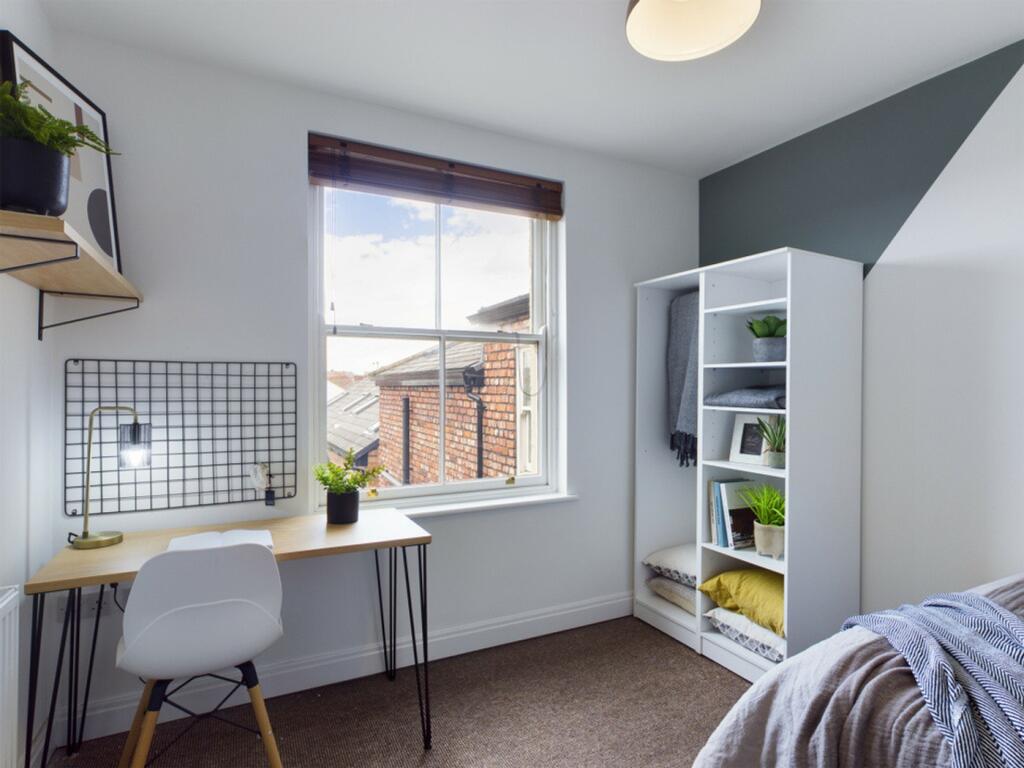 A bright and inviting double bedroom with a sty...