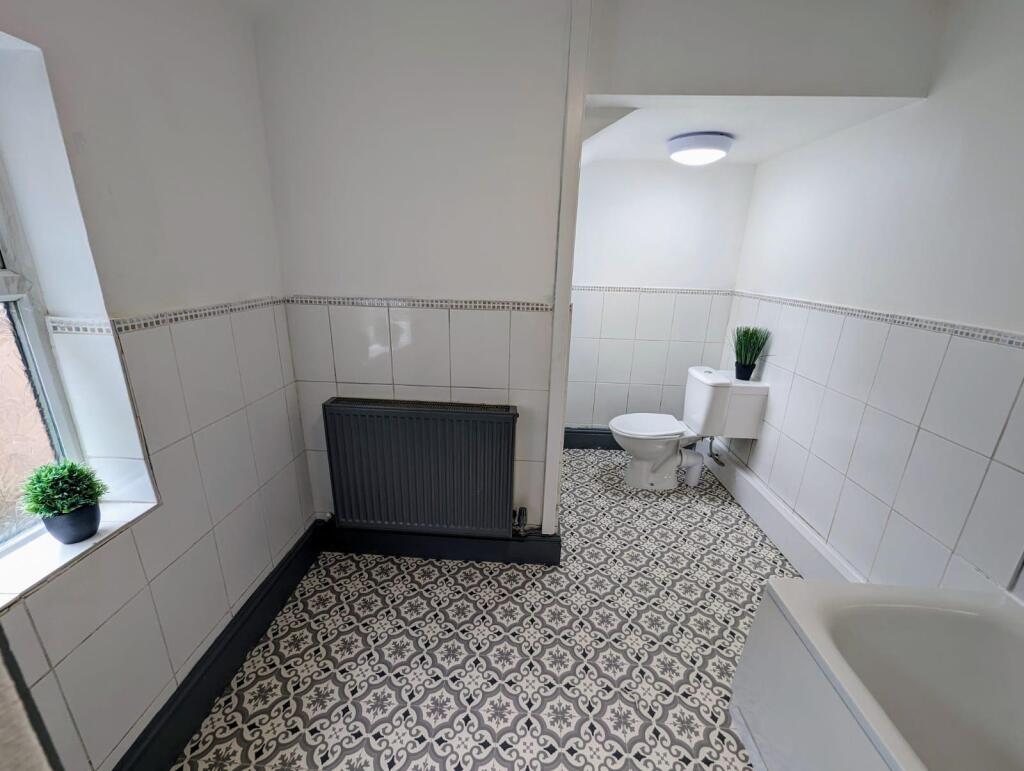 Bright and clean bathroom suite featuring decor...