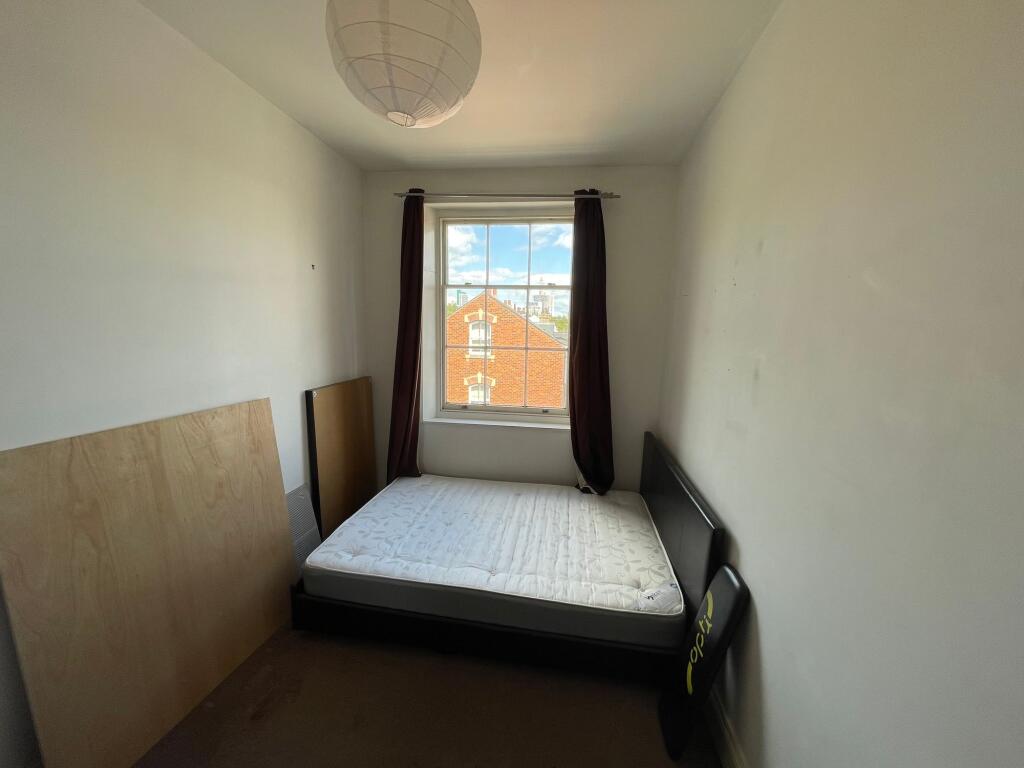 A simple double bedroom featuring a large windo...