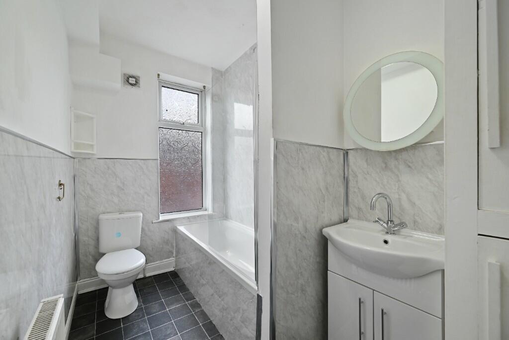 Bright and clean bathroom suite featuring a mod...