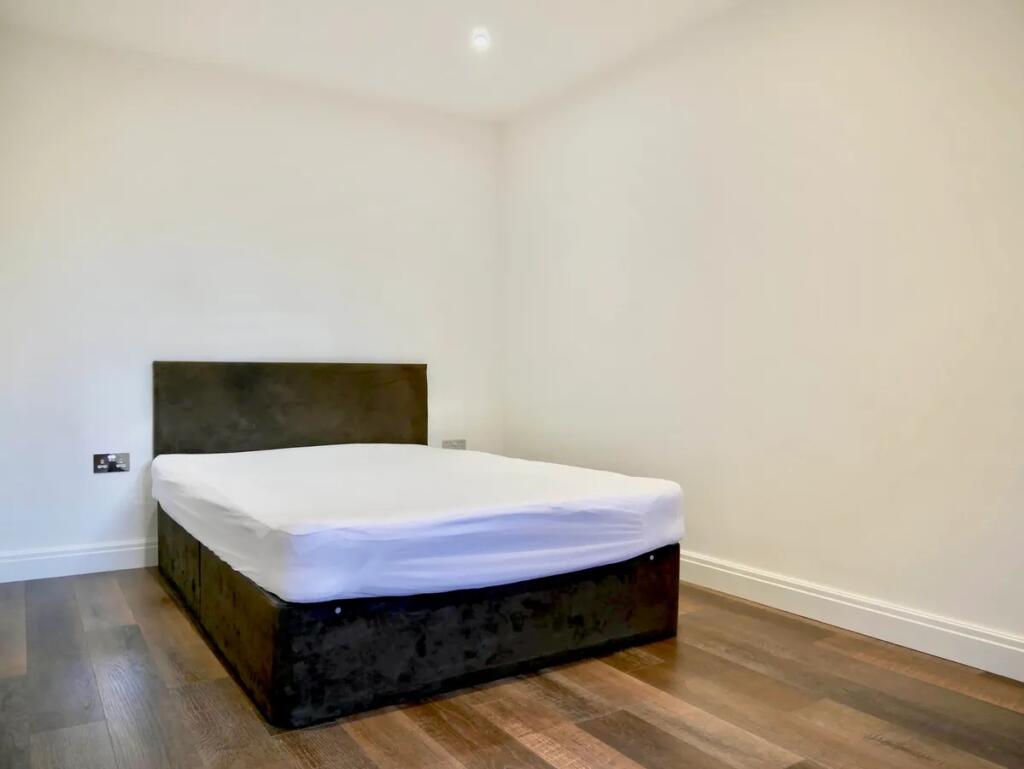 A clean and modern double bedroom featuring a d...