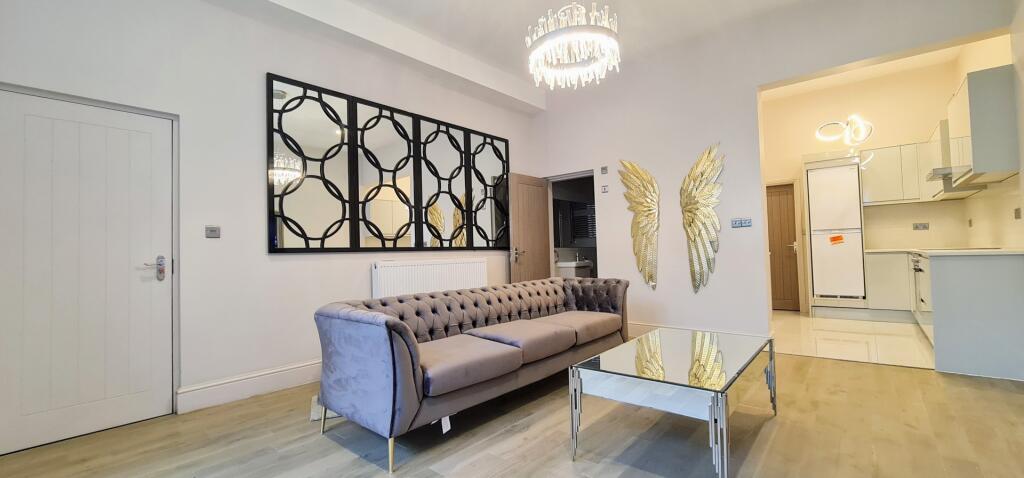 A well-lit, spacious living room with modern fu...