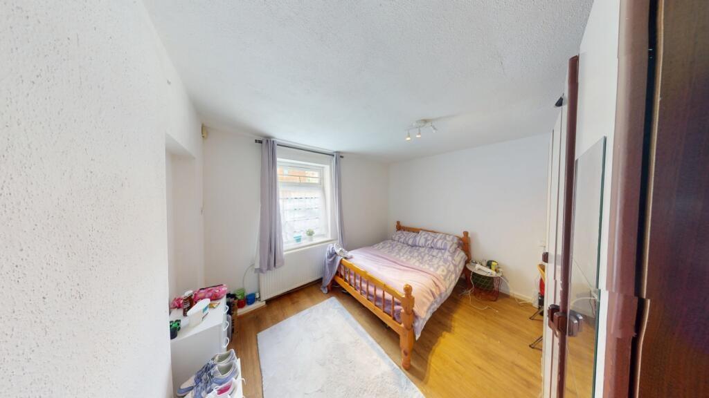 A cozy double bedroom featuring a wooden framed...