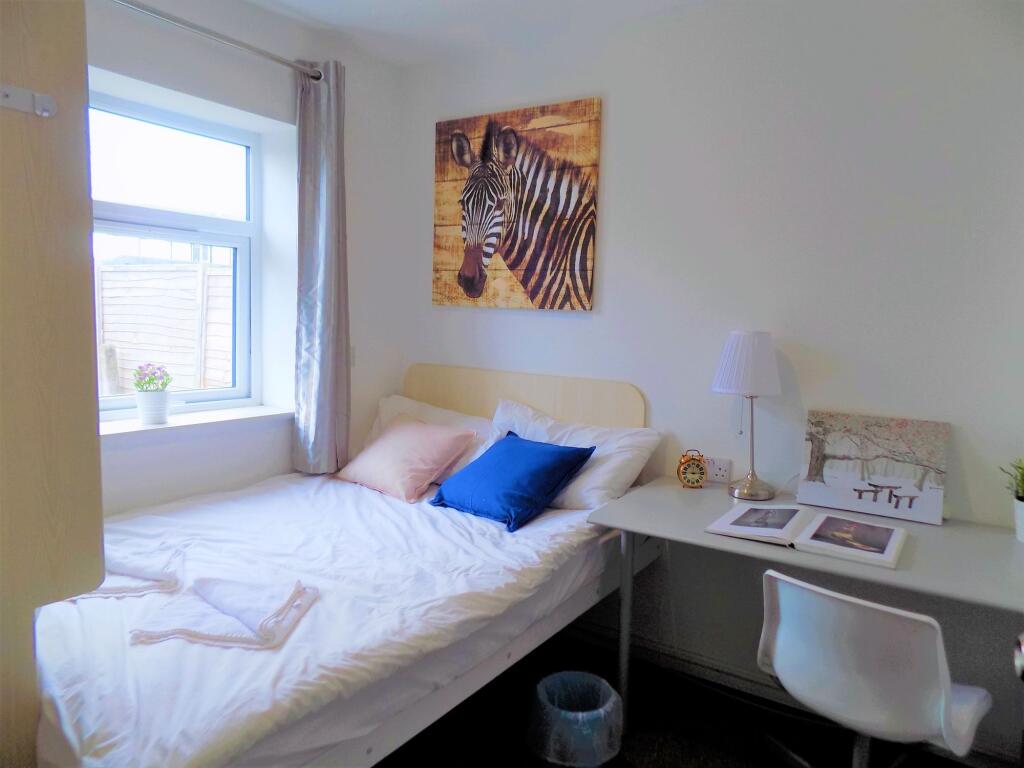 A cozy single bedroom featuring a comfortable b...