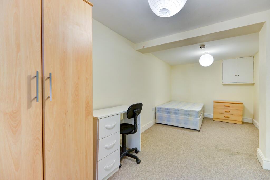 A neat and functional single bedroom featuring ...