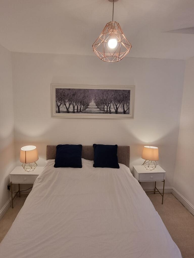 A cozy, well-lit bedroom featuring a double bed...