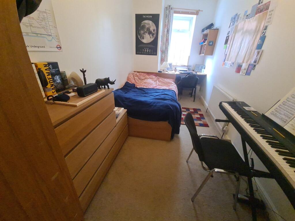A cozy single bedroom featuring a comfortable b...
