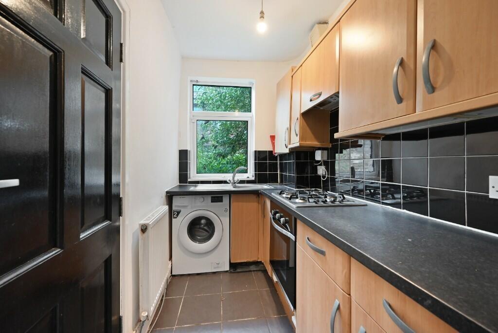 Bright and tidy kitchen featuring modern wooden...