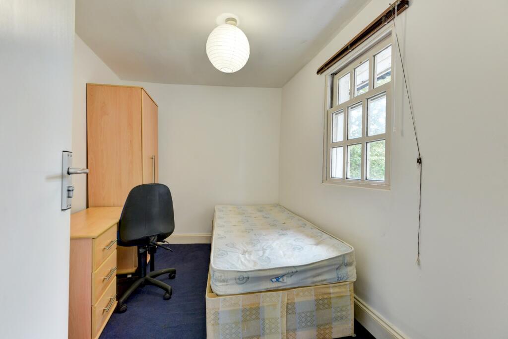 A bright and tidy single bedroom featuring a we...