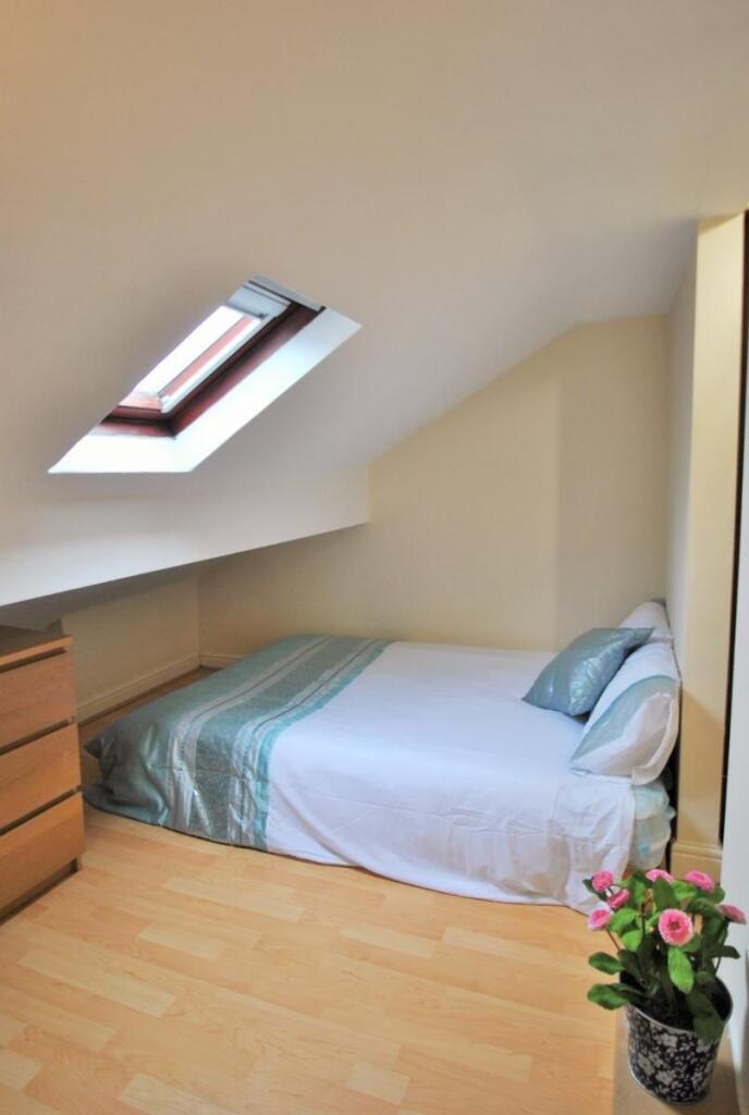 Bright attic bedroom with a skylight, neat sing...