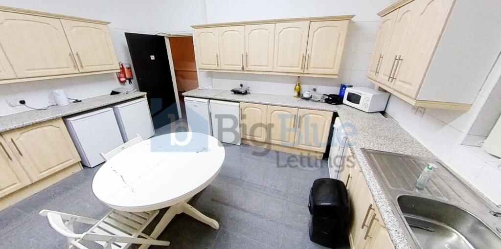 A bright and tidy kitchen featuring cream cabin...