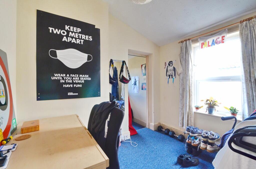 A cozy single bedroom featuring a desk and chai...