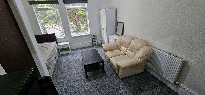 Well-lit furnished bedroom with large front win...