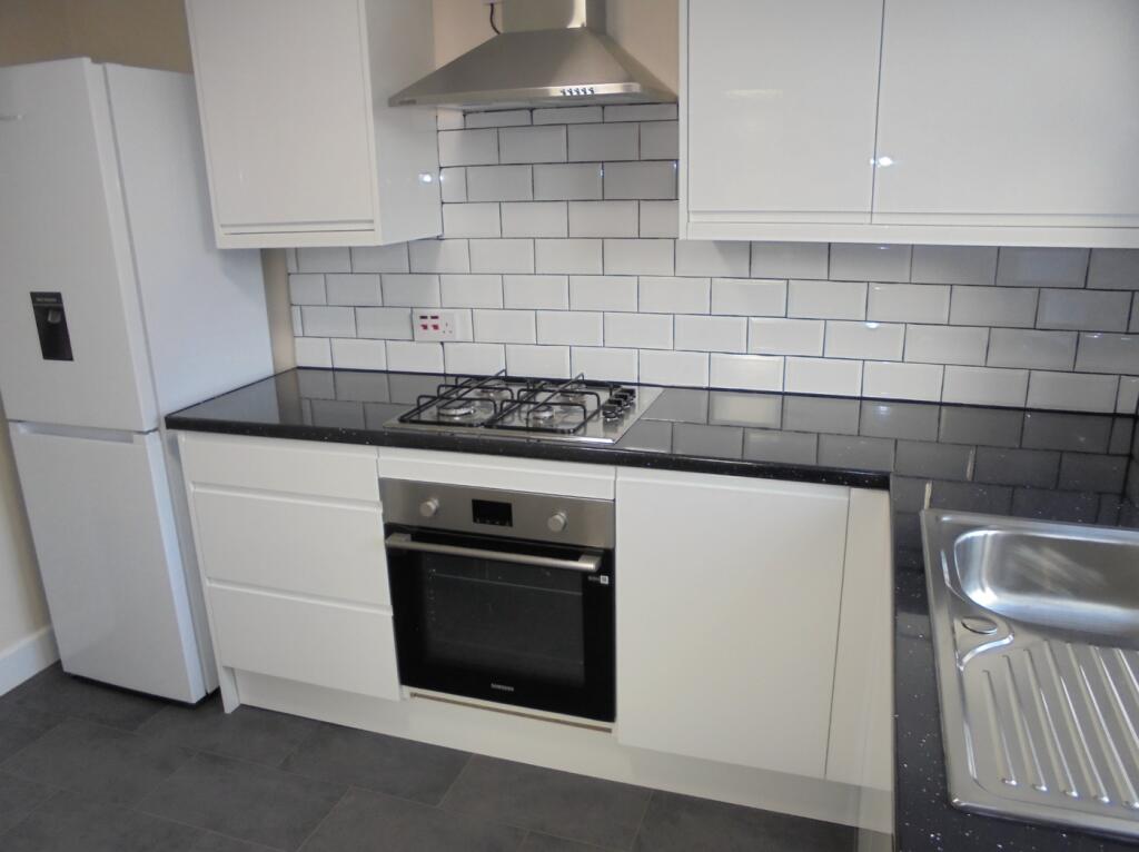 A modern and pristine kitchenette featuring sle...