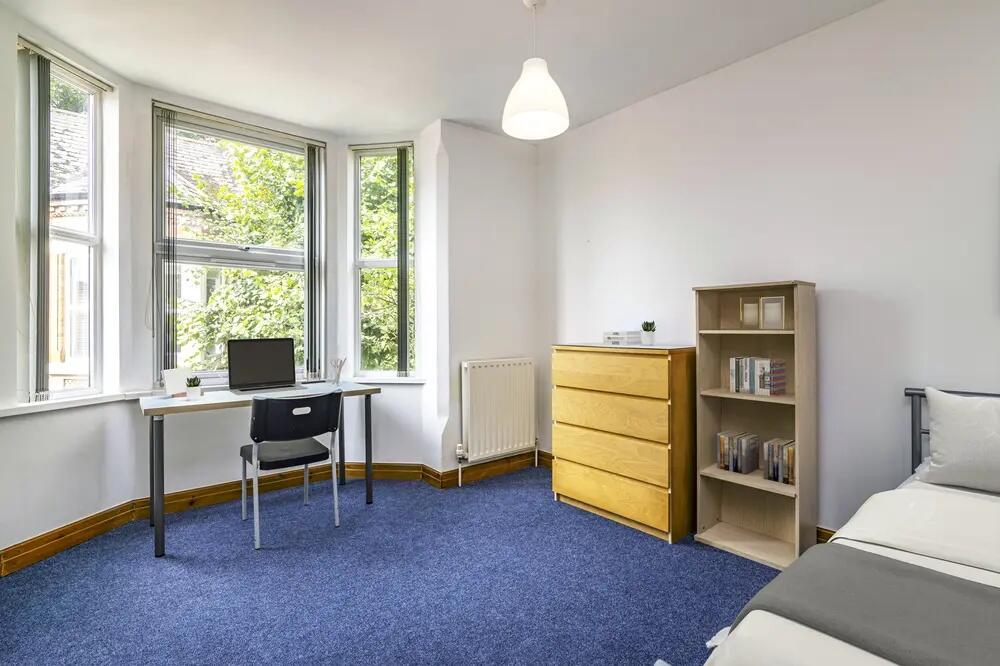 Bright and airy bedroom featuring a large bay w...