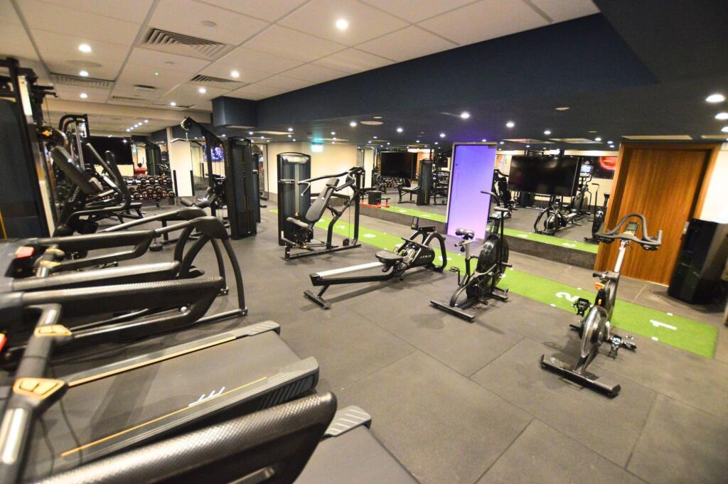 A modern gym equipped with multiple treadmills,...