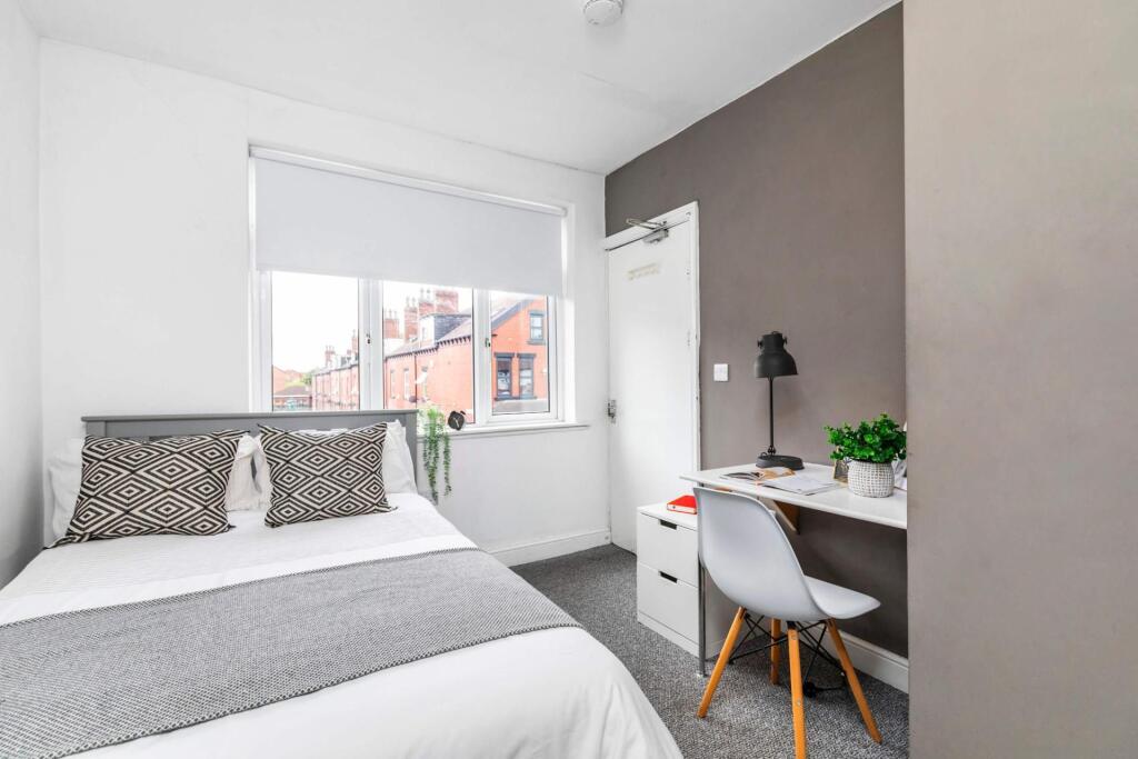 A bright and tidy bedroom featuring a comfortab...