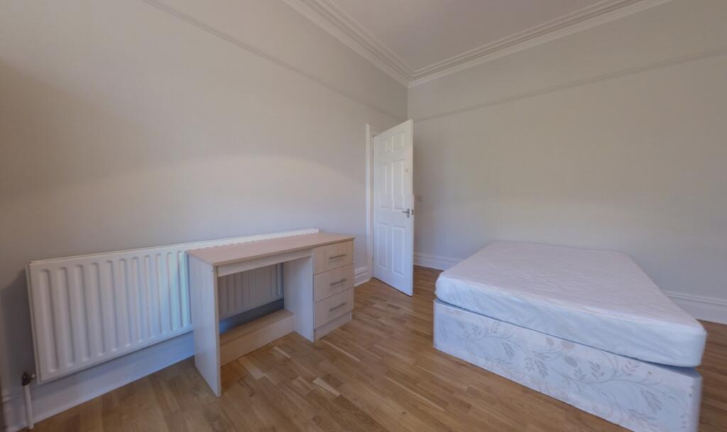 A bright and tidy bedroom featuring a single be...
