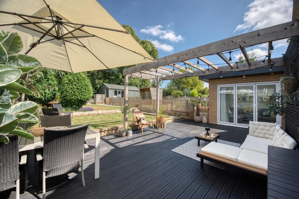 Garden - decking and pergola towards bifold doors.