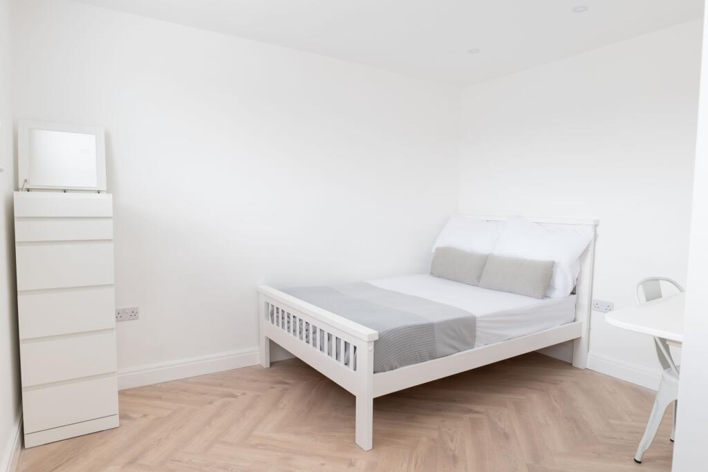 A bright and tidy double bedroom featuring a wh...