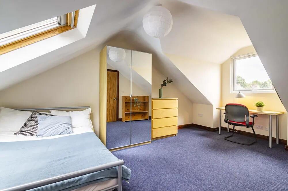 Bright and cozy bedroom featuring a comfortable...