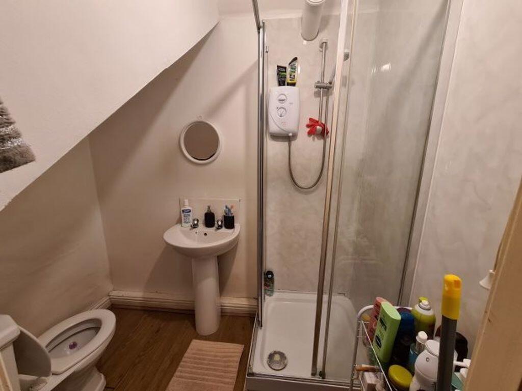 A bright, modern bathroom featuring a shower un...