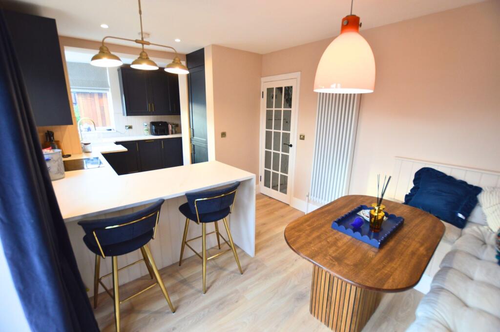 A modern kitchen with stylish dark cabinetry an...