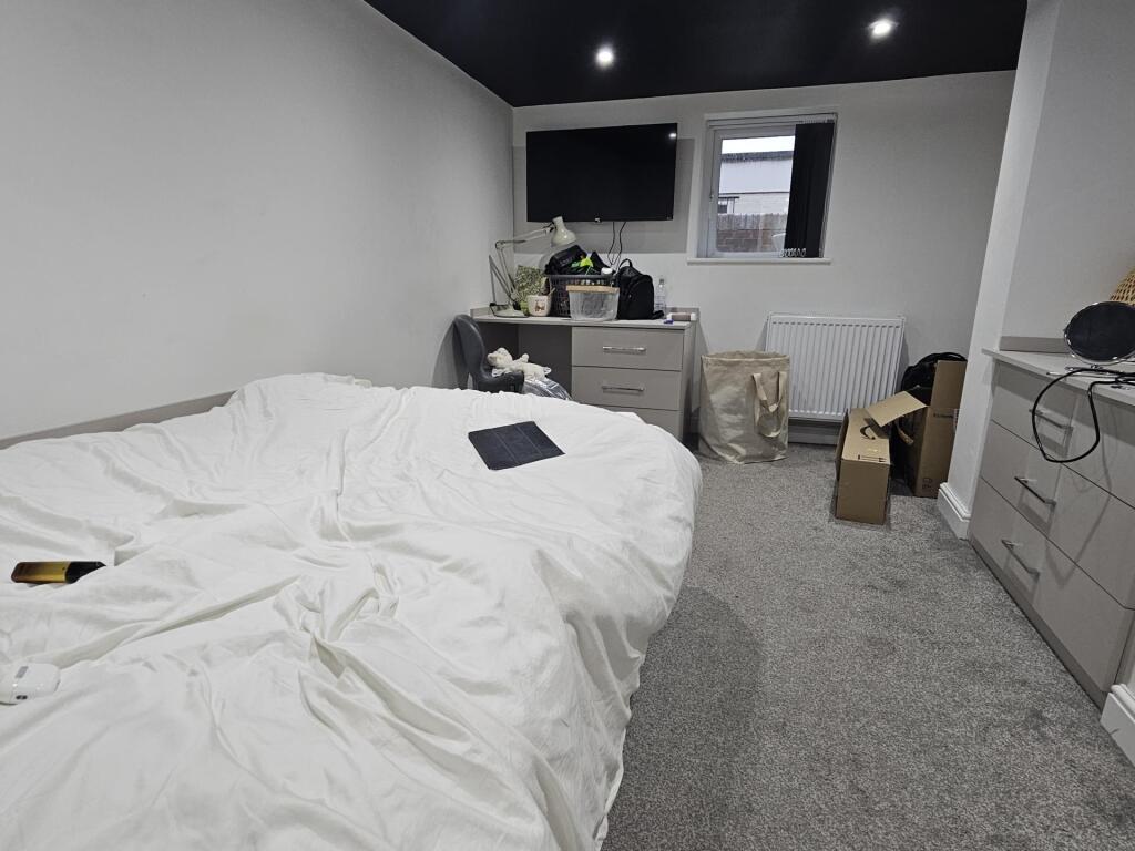 A well-maintained bedroom featuring a large dou...