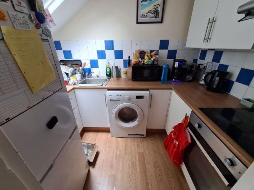 Bright, tidy kitchen with contemporary white ca...