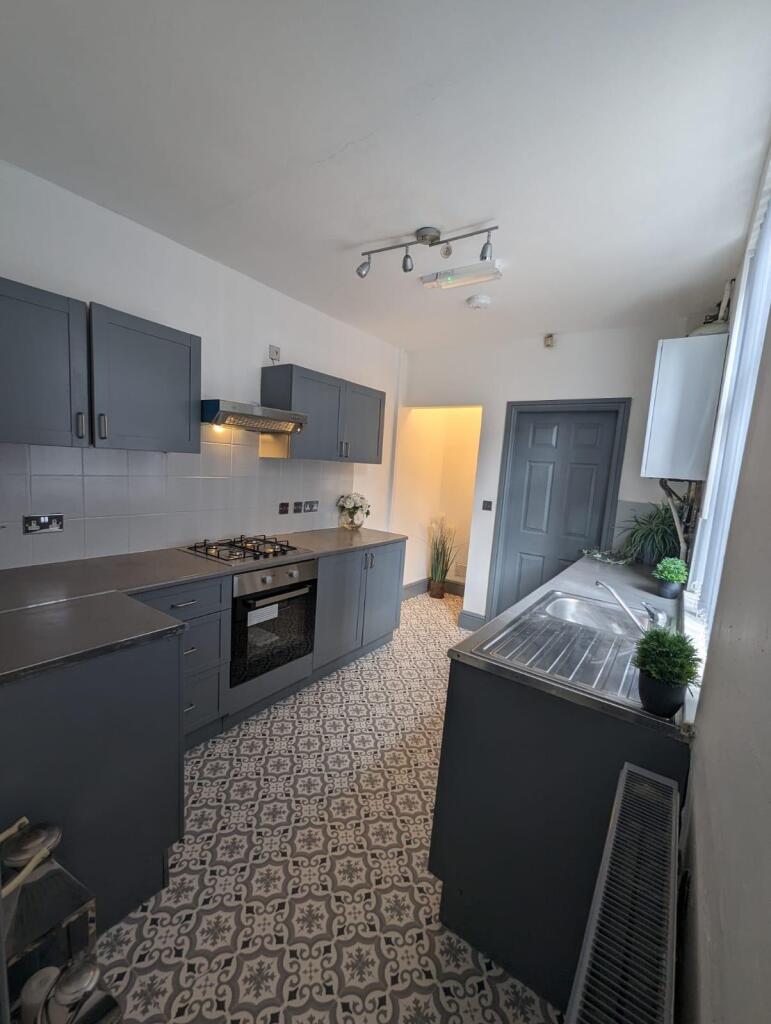 A charming kitchen featuring sleek grey cabinet...