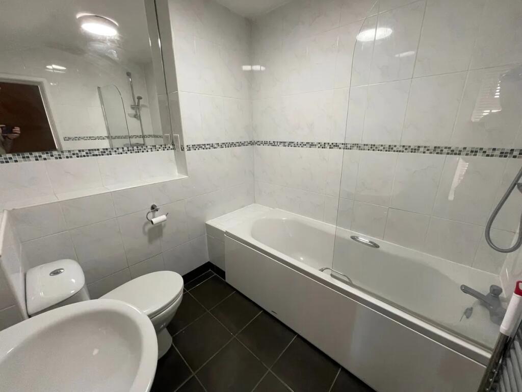A modern bathroom suite featuring a clean white...