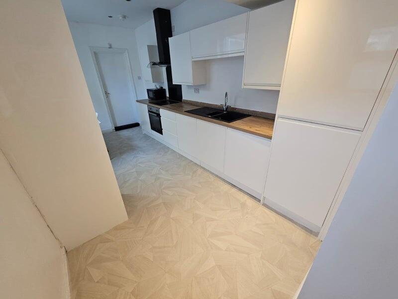 A modern kitchen featuring sleek white cabinetr...