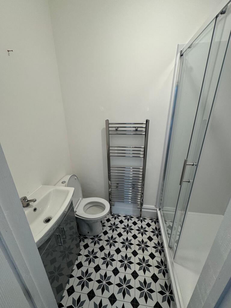 A modern bathroom featuring a patterned black a...