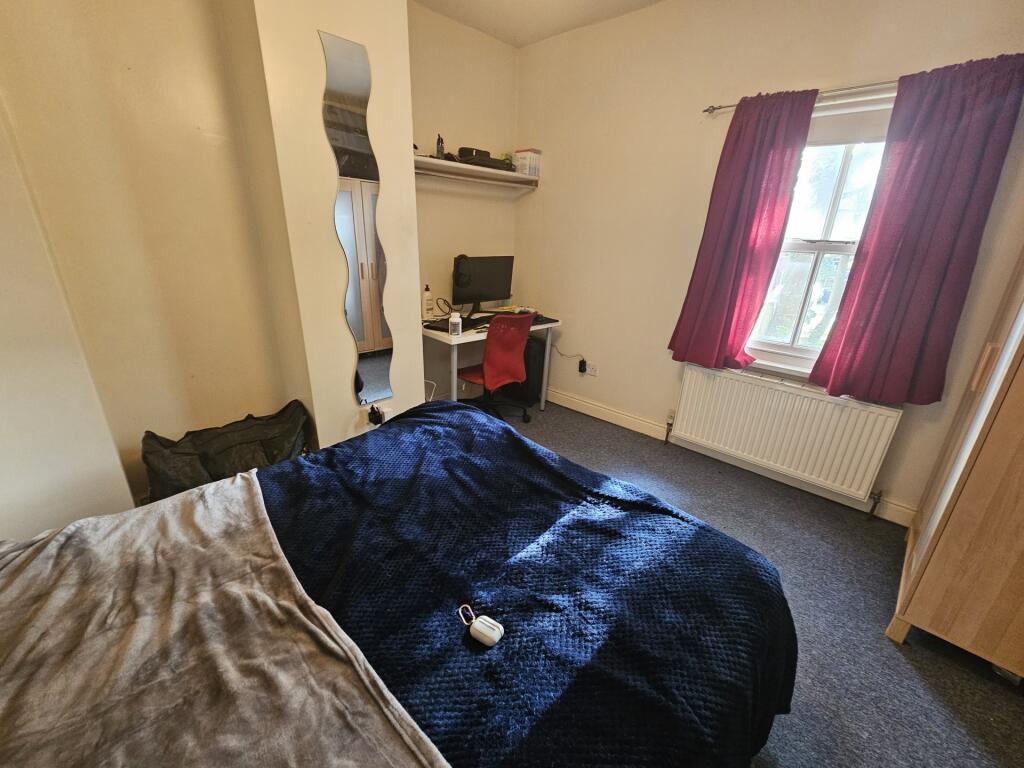 A cozy bedroom featuring a double bed with dark...